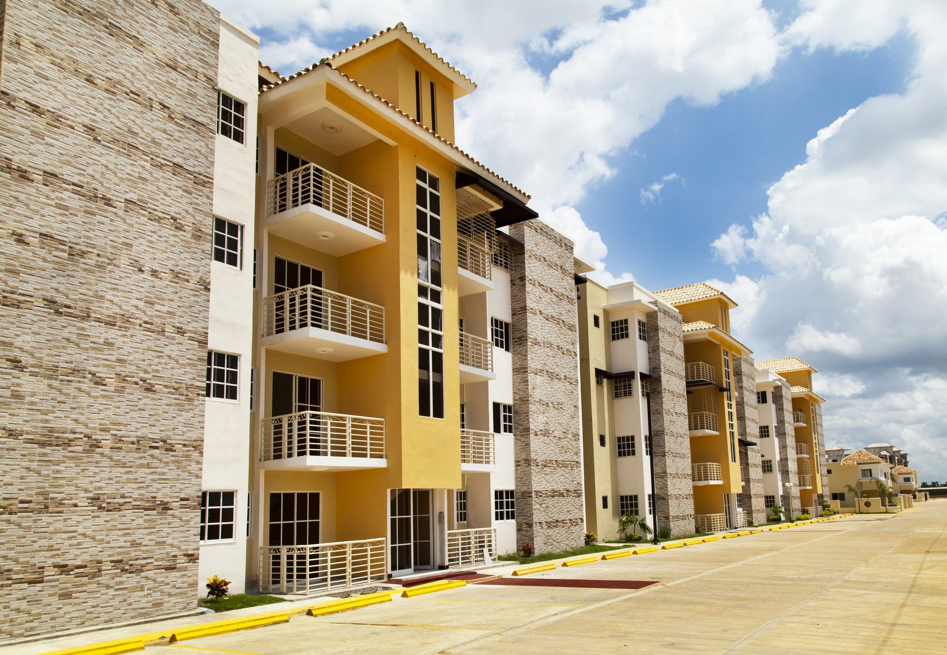 Fachada terminada de apartamentos con balcones y revestimiento en piedra, proyecto Las Palmeras