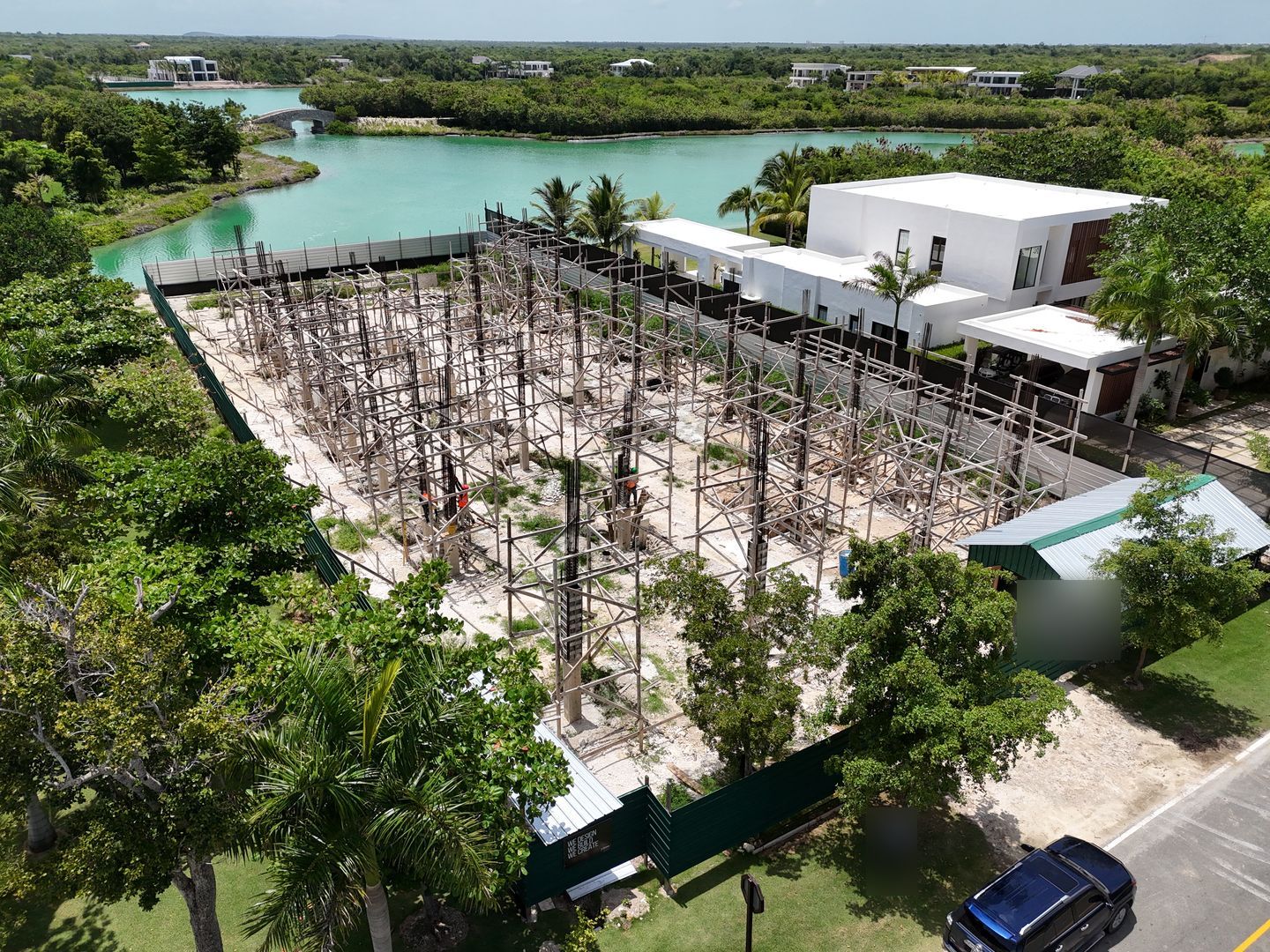 Villa en Lagos Punta Cana: vista aérea de la obra gris junto a una laguna turquesa